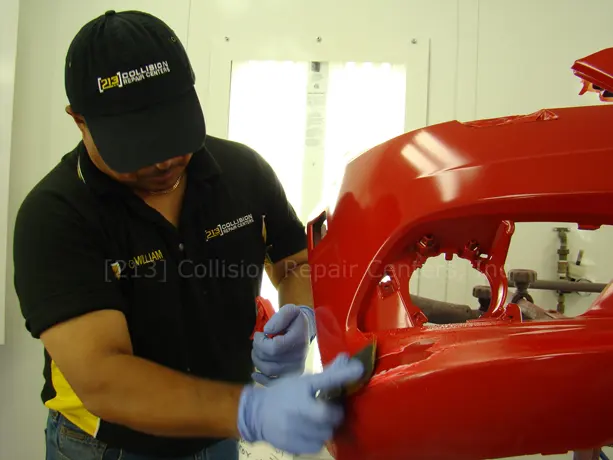 Technician preparing a bumper for paint at 213 Collision