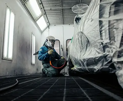 Technician blending paint colors in the paint mixing area at Avio Coach Craft