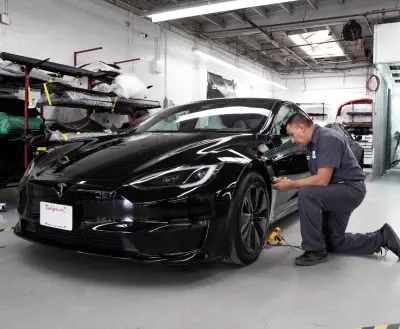 Technician performing precision dent removal at Avio Coach Craft
