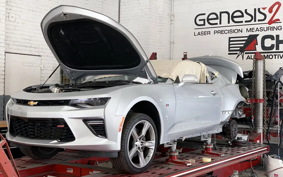 Car mounted on a frame bench with laser measuring system inside the shop