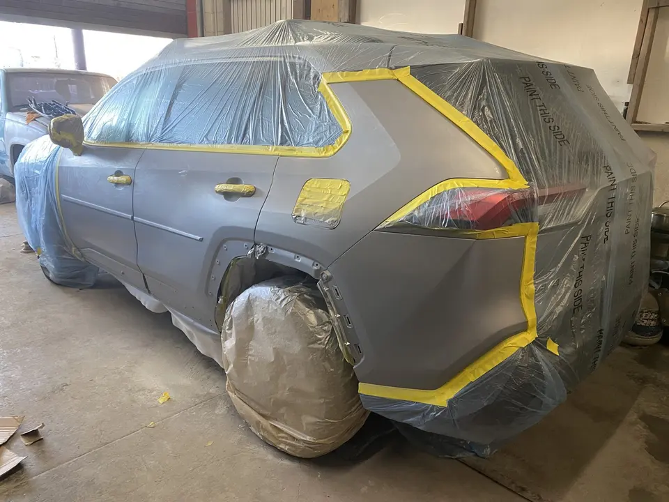 SUV masked for paint inside the El Shaddai shop