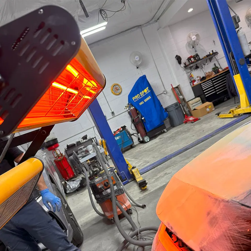 Paint curing lamp over a panel in a GB Auto Body repair bay