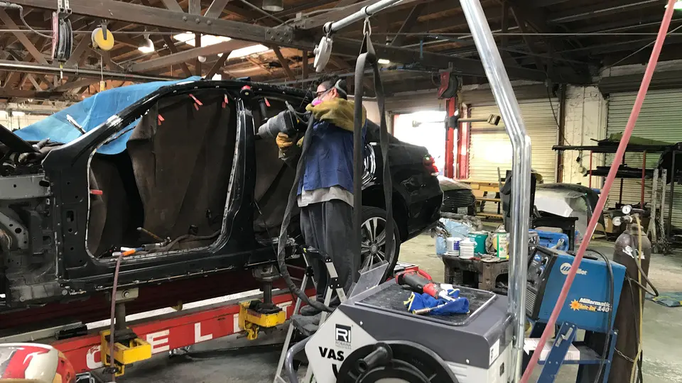 Repair bay at Glendale Auto Body with a vehicle on a frame bench