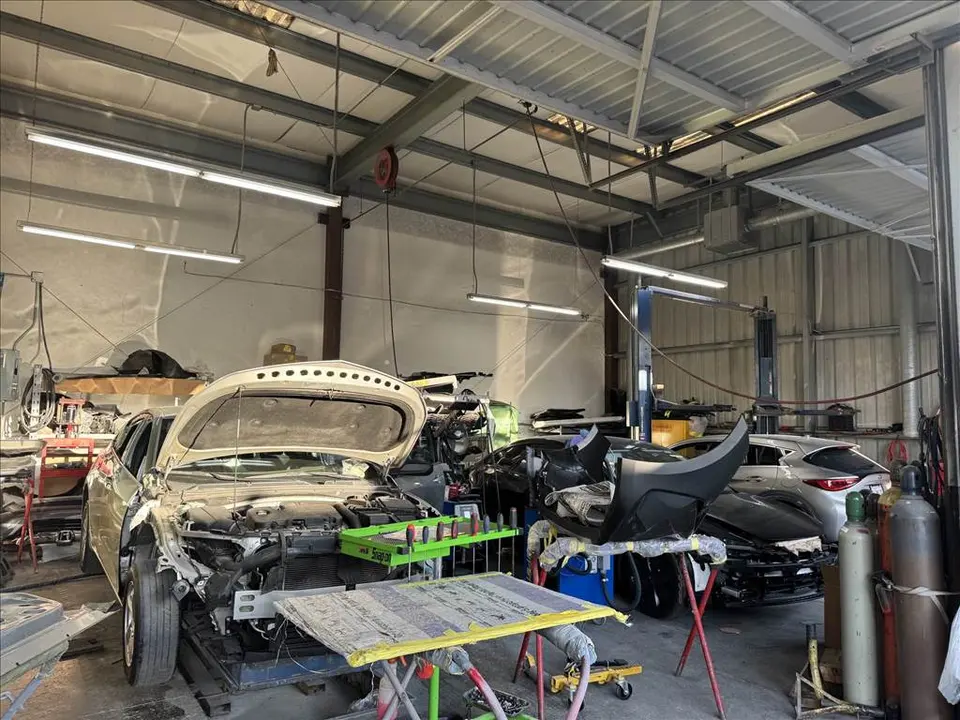 Shop floor with vehicles under repair at Mac Auto Collision