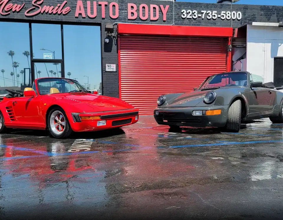 New Smile Auto Body storefront on Venice Blvd with two classic Porsches out front