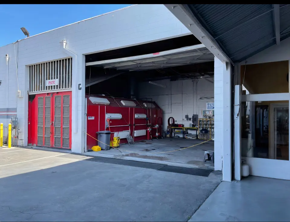 Open bay door with paint booth at The California Auto Body Shop