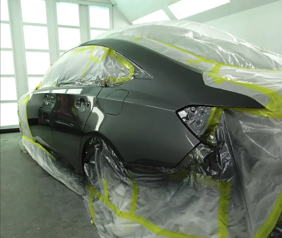 Technician polishing a car inside the Yosemite Auto Body shop